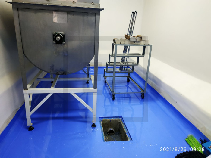 Piso industrial en área de producción farmacéutica con registro de alcantarillado